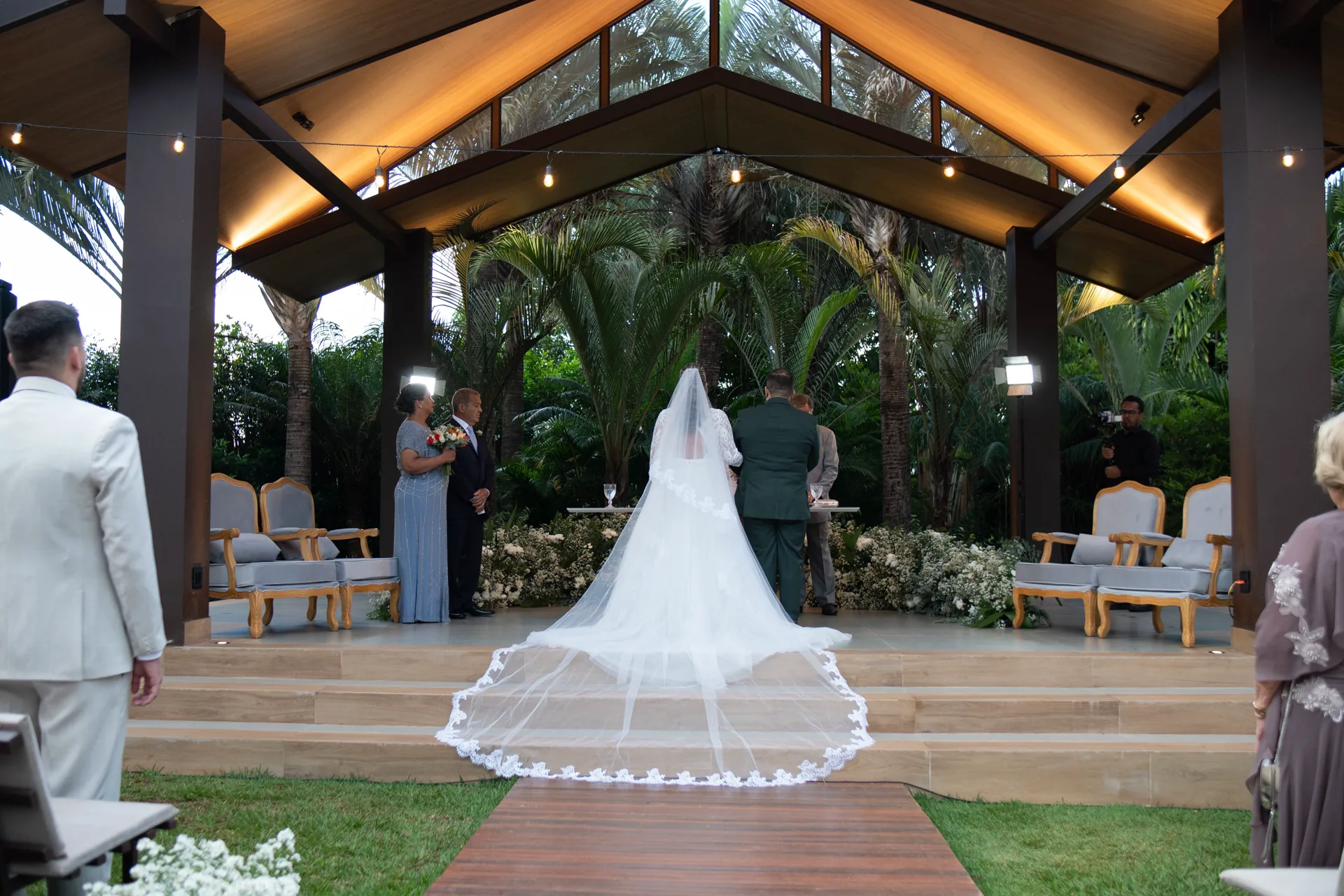 Noiva caminha em direção ao altar em cerimônia no jardim