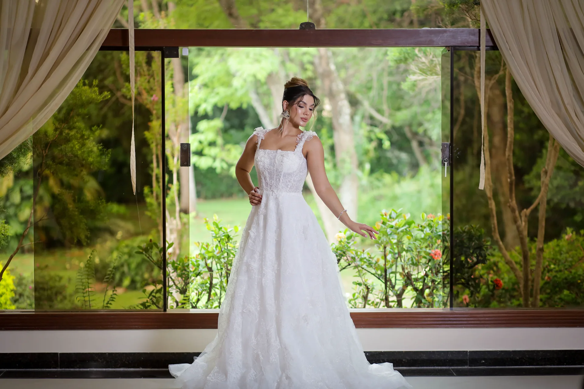 Noiva pronta, junto a uma grande janela voltada para o jardim